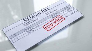 Medical bill marked final notice on reflective desk surface