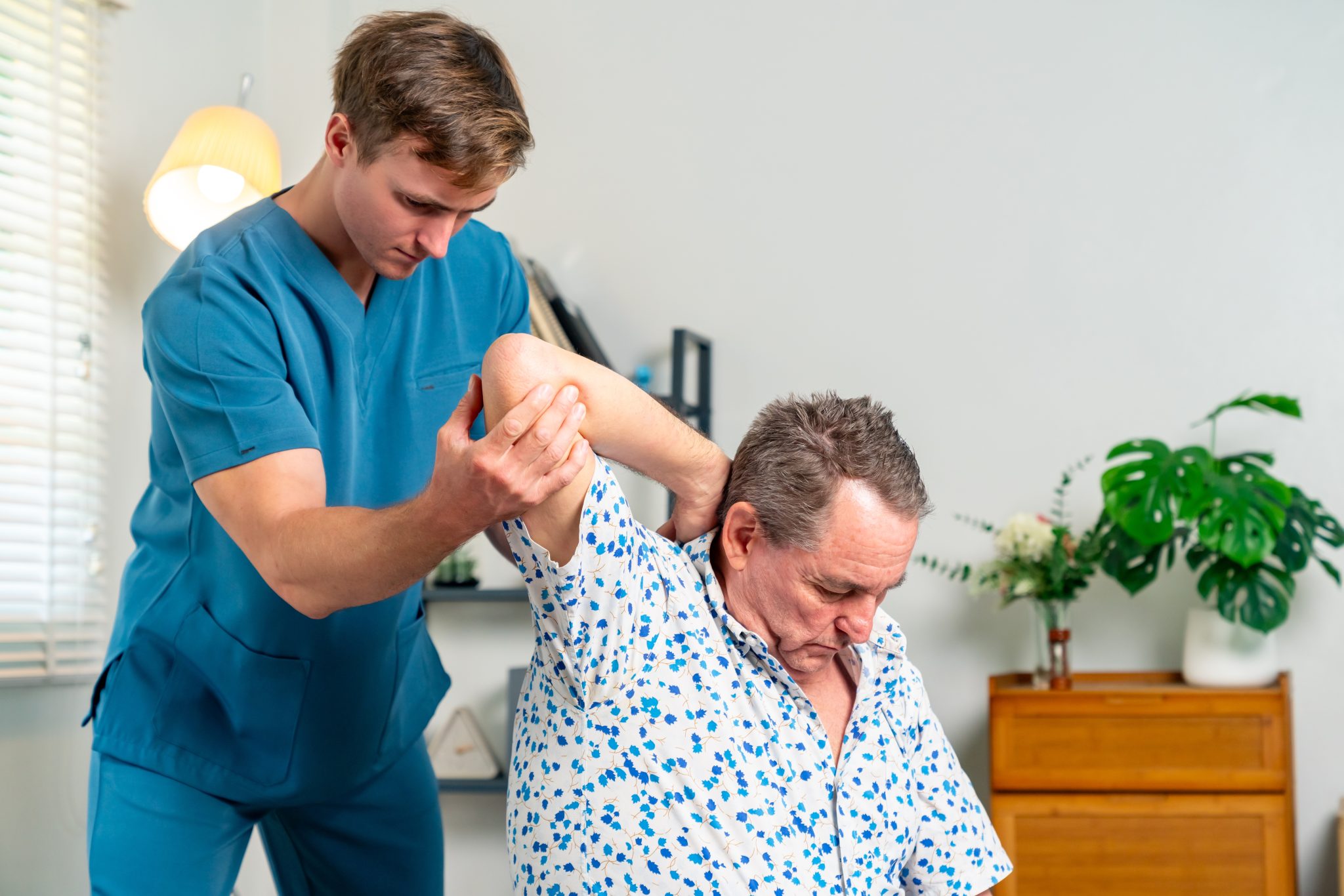 Healthcare provider smiling and supporting an older adult, symbolizing the human connection behind the elder care workforce.